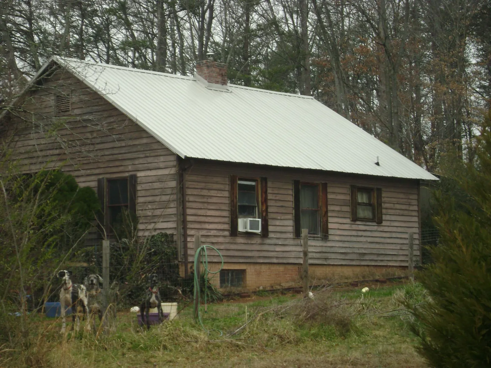 White metal roof on an old wood sided farmhouse, from a Metal Roof Installation job in Ashford